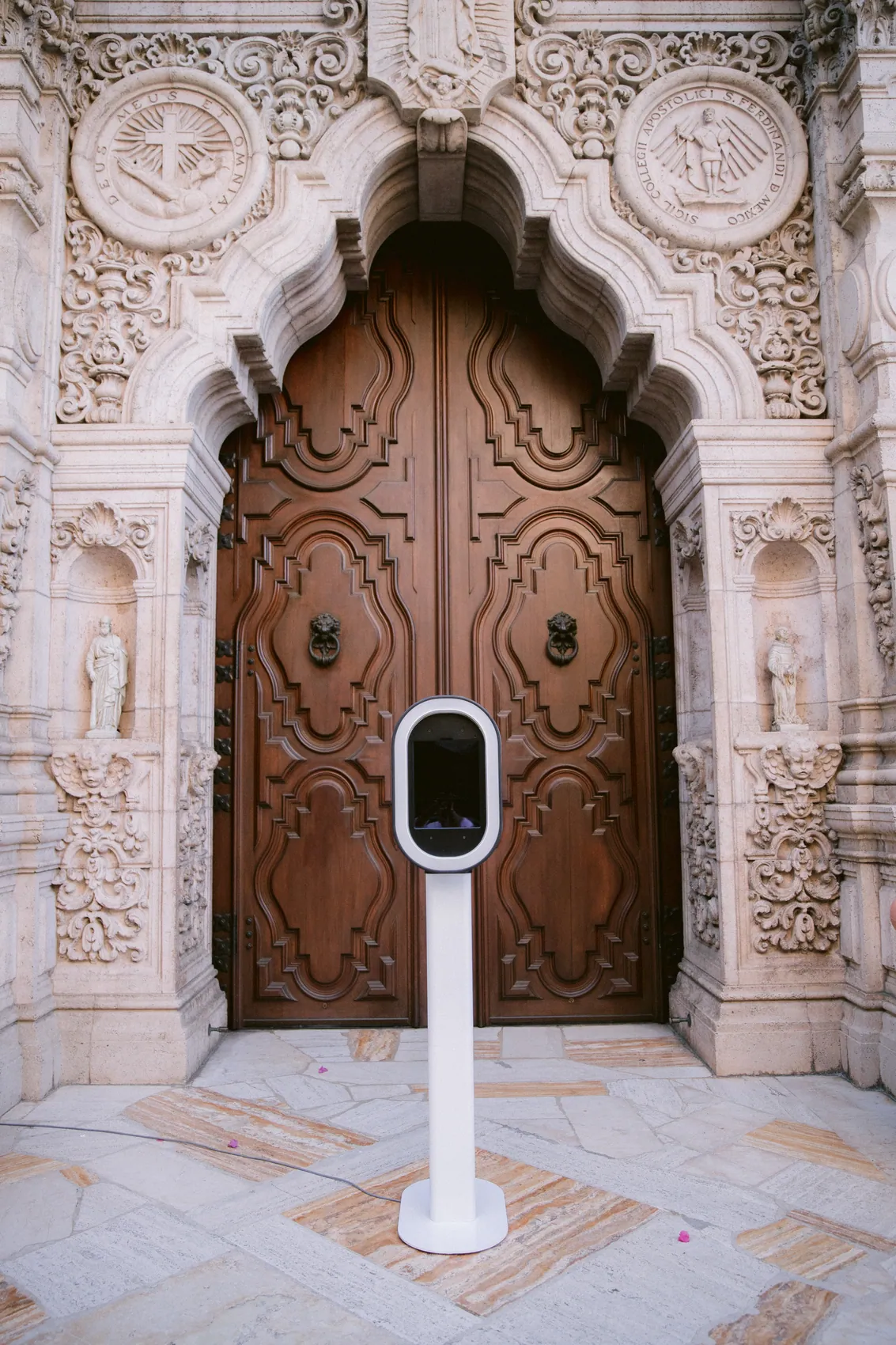An open air booth waiting in front of a carved wooden doorway before guests arrive