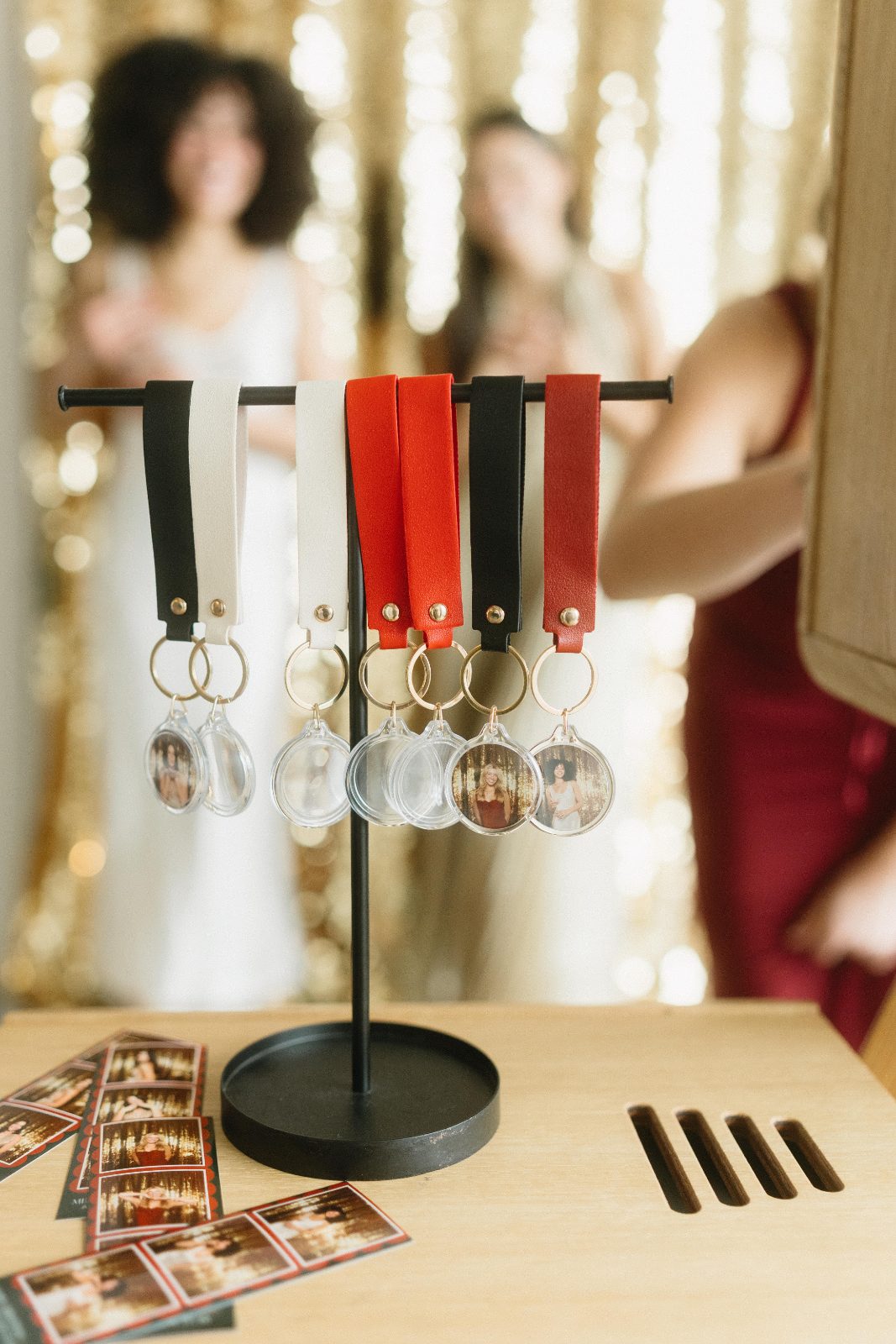 A close view of the keychain rack, red, black and cream leather tabs on gold rings, with finished strips laid out below
